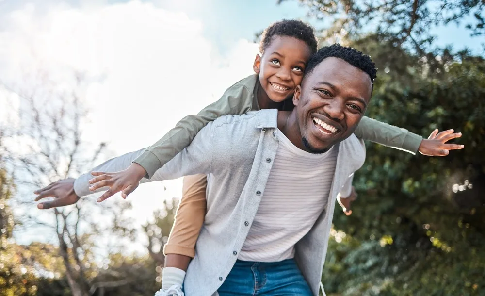 Father giving his child a piggyback ride outdoors
