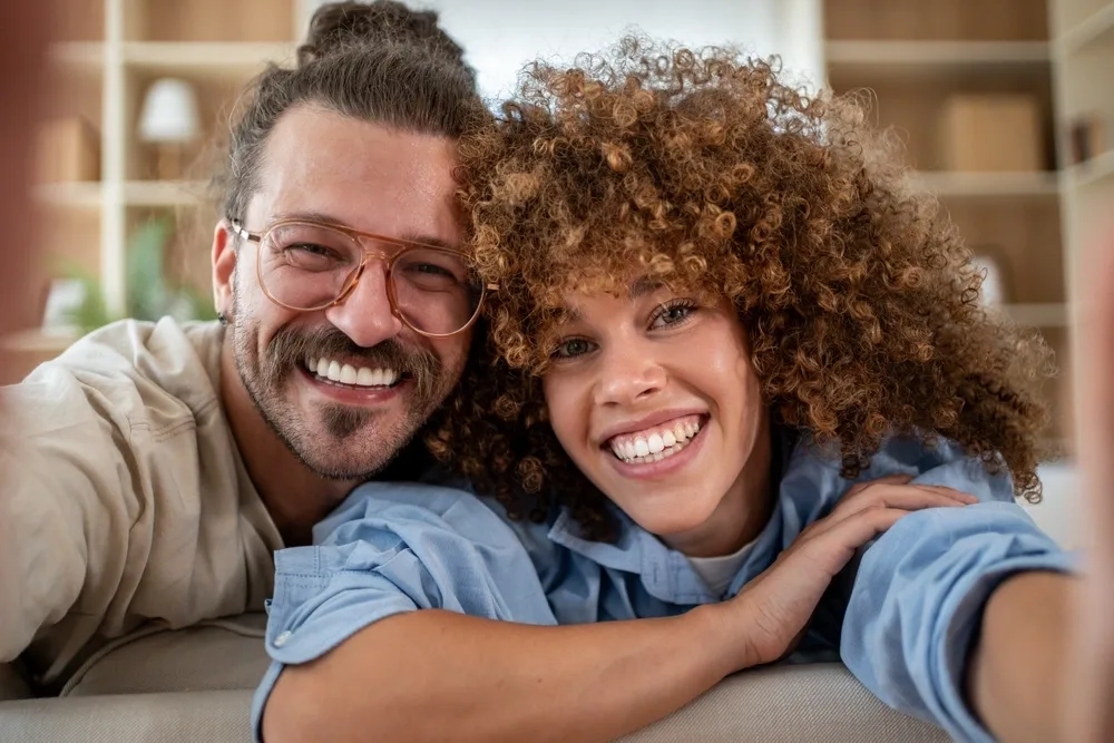 Smiling Patients Smiling couple sitting cheek to cheek indoors